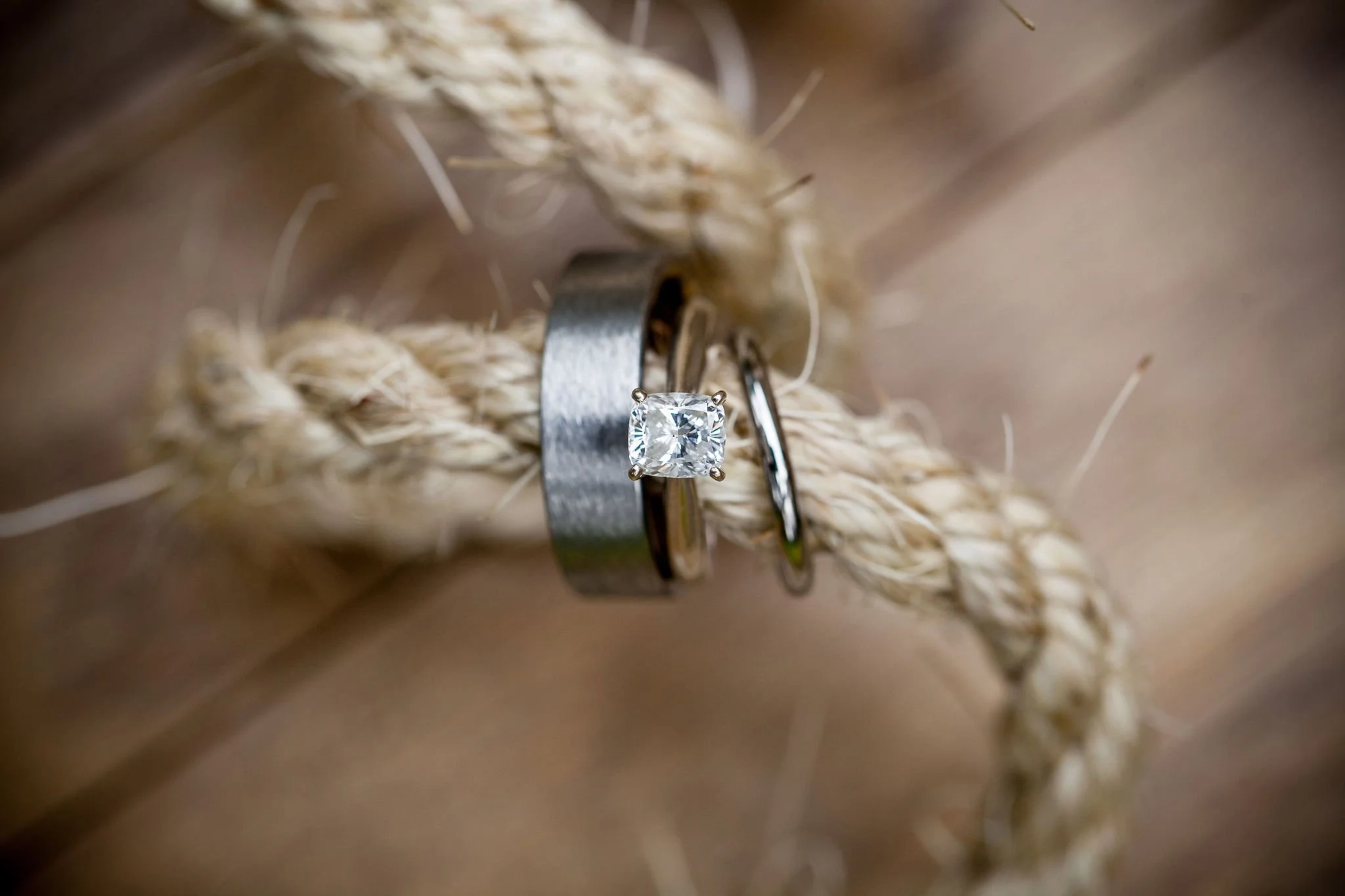Close-up of a diamond engagement ring and a wedding band on a piece of rope.
