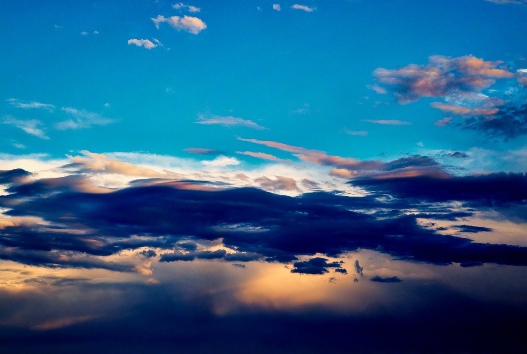 Close up detail from "Hold On" photographic wall art. The artwork shows storm clouds crossing the beginning sunset in an otherwise blue sky at Pambula Beach.