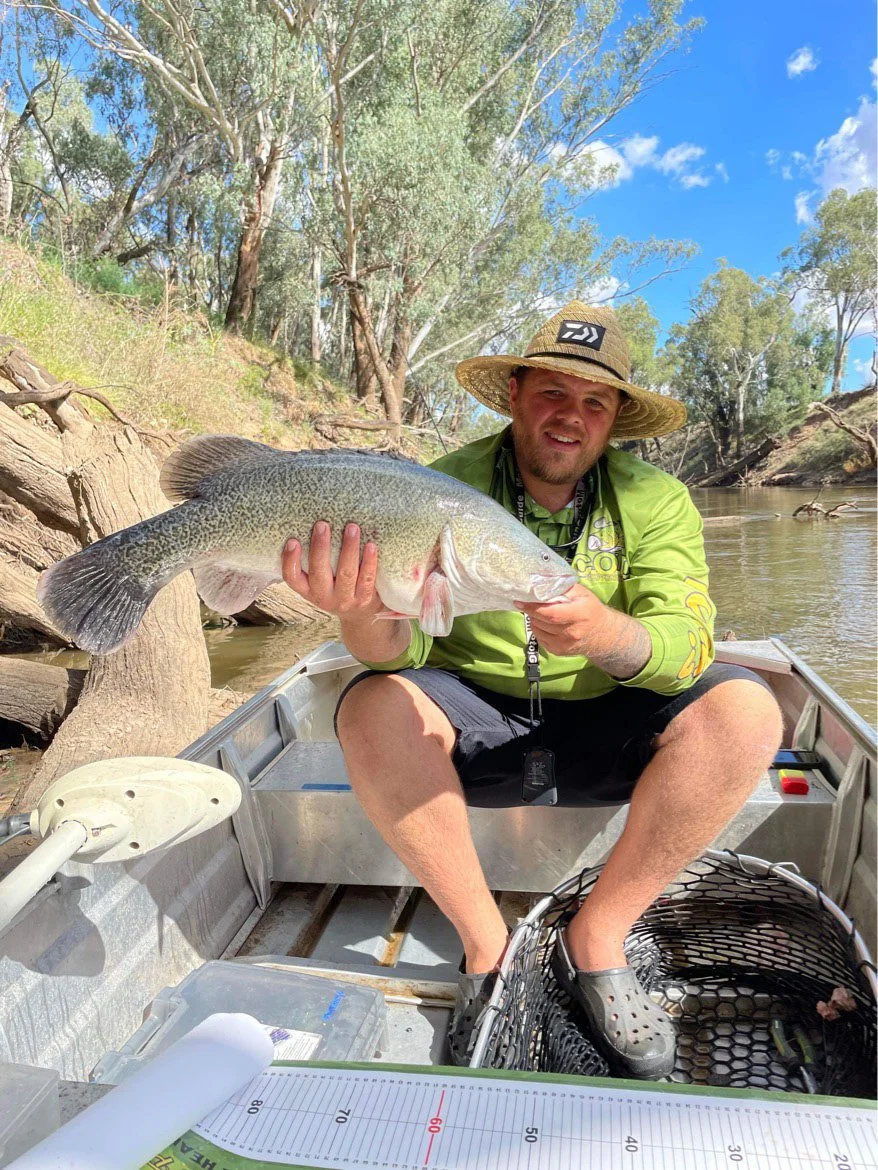 Dane holding up a cod wearing his COD Tales fishing shirt