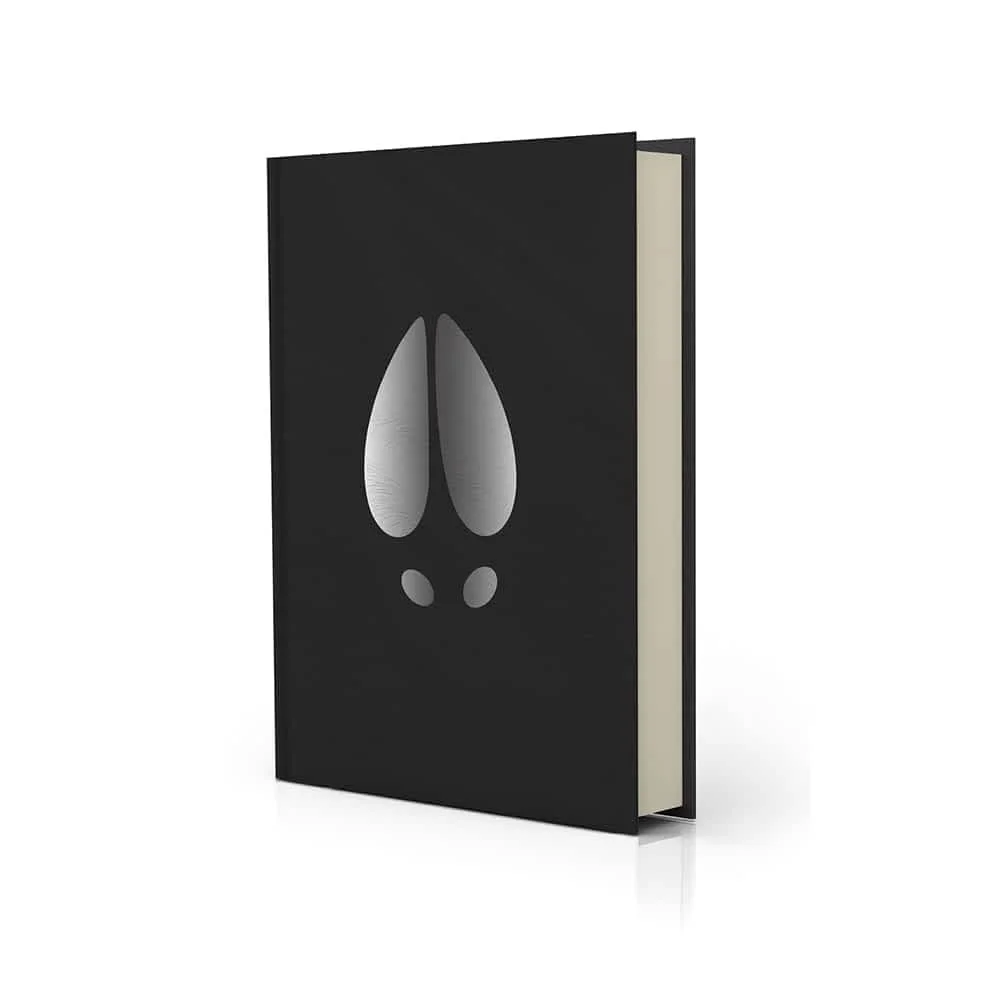 Black hardcover book with a stylized design resembling a hoof print on the cover, standing upright with pages slightly visible.