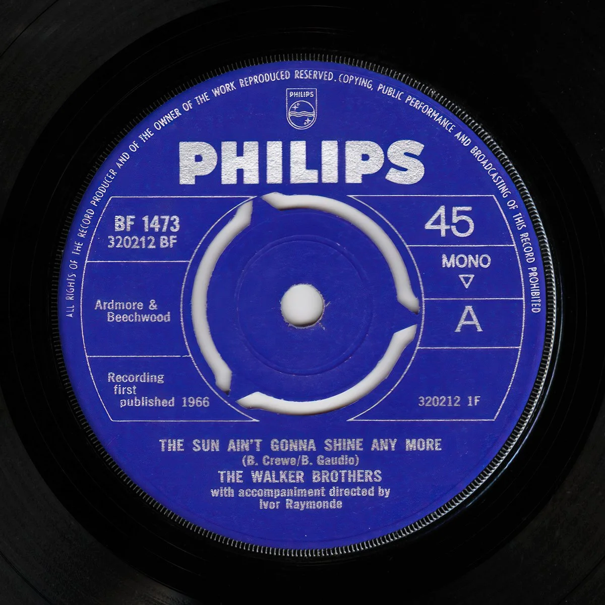 Close-up of a vintage Philips 7" vinyl record with a blue label. It features the song "The Sun Ain't Gonna Shine Any More" by The Walker Brothers, with details about the record and production.