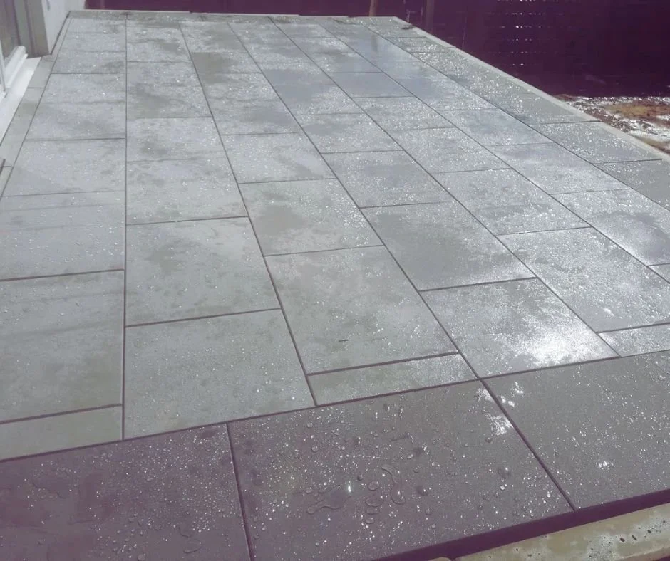 Feuchte Terrassenplatte mit Wassertröpfchen, niedriger Blickwinkel, Außenbereich