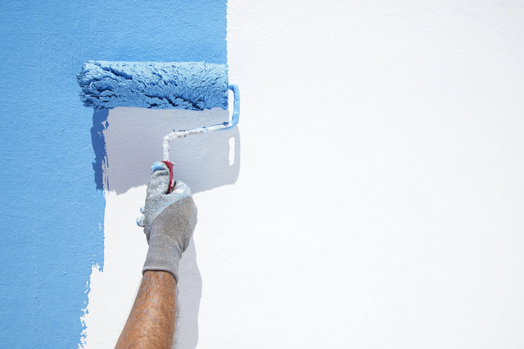 Man from RPM Painting who is painting a wall with a roller paint brush.