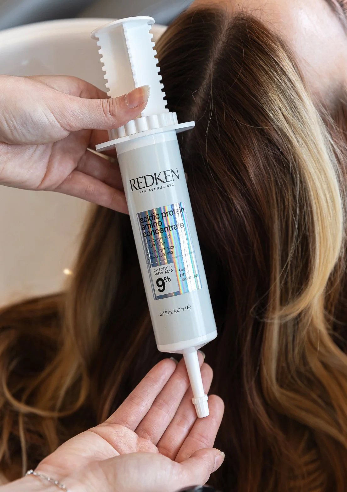 A close up of Redken acidic protein amino concentrate hair product.