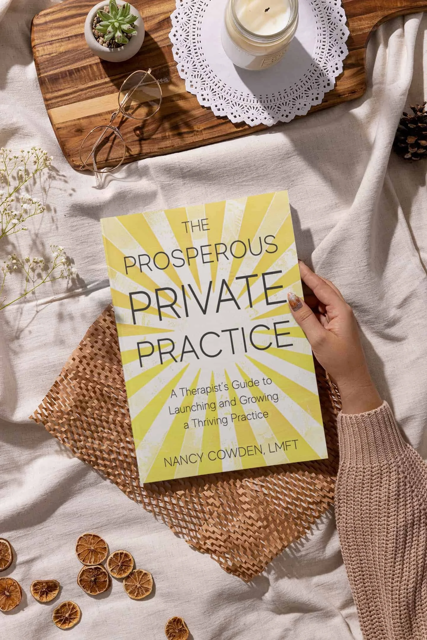 Hand holding The Prosperous Practice Book.