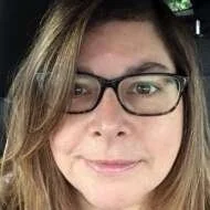 Close-up of a woman with glasses, light brown hair, and a slight smile. CAtherine Canning, Biodanza Glasgow