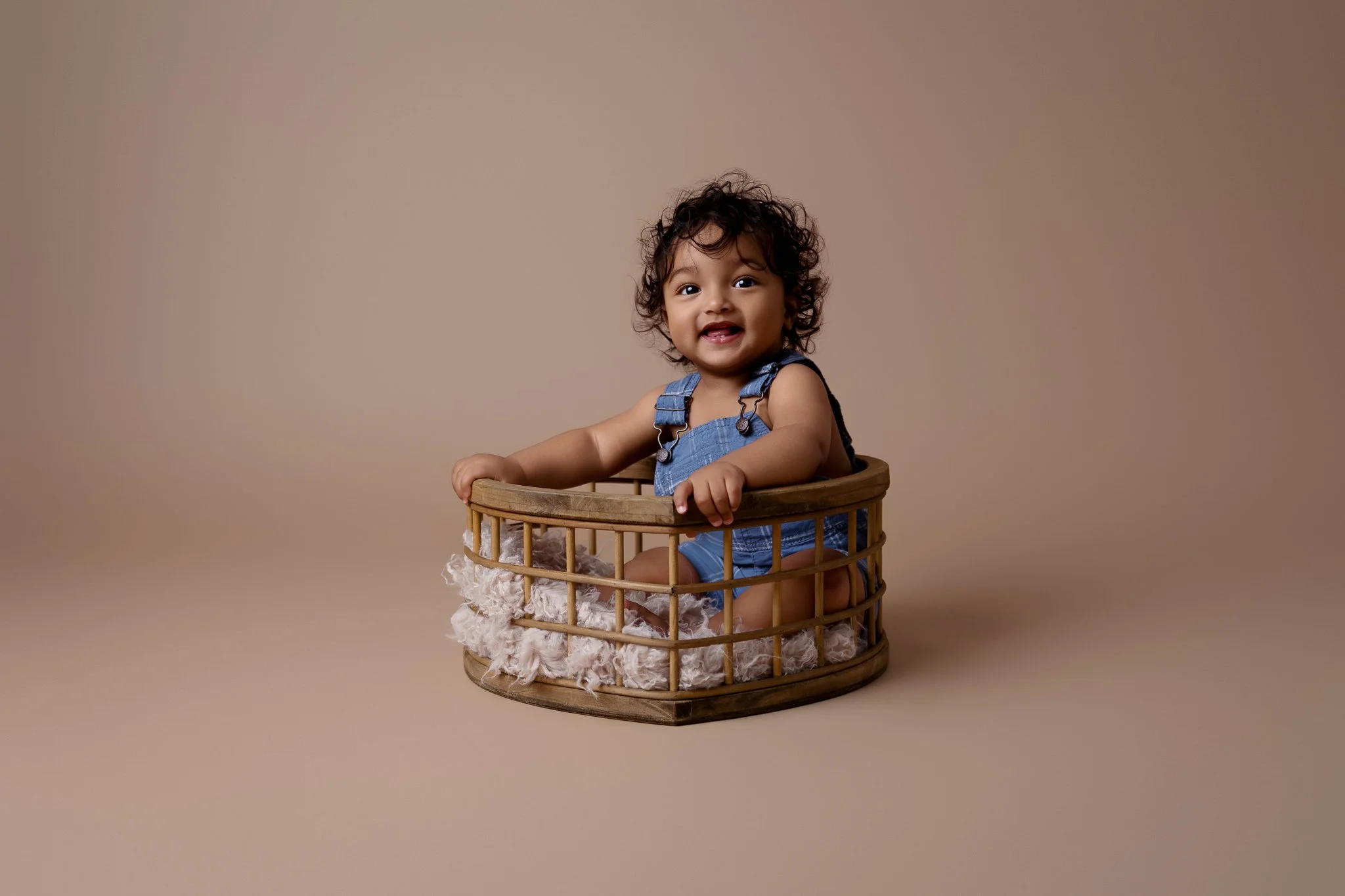 A toddler is sitting in a heart basket.