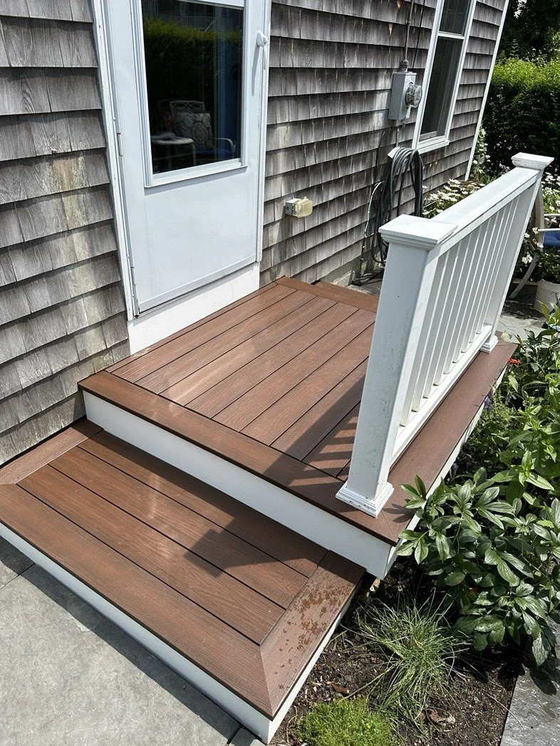 Composite porch and entry steps with white railing in Cohasset, Massachusetts.