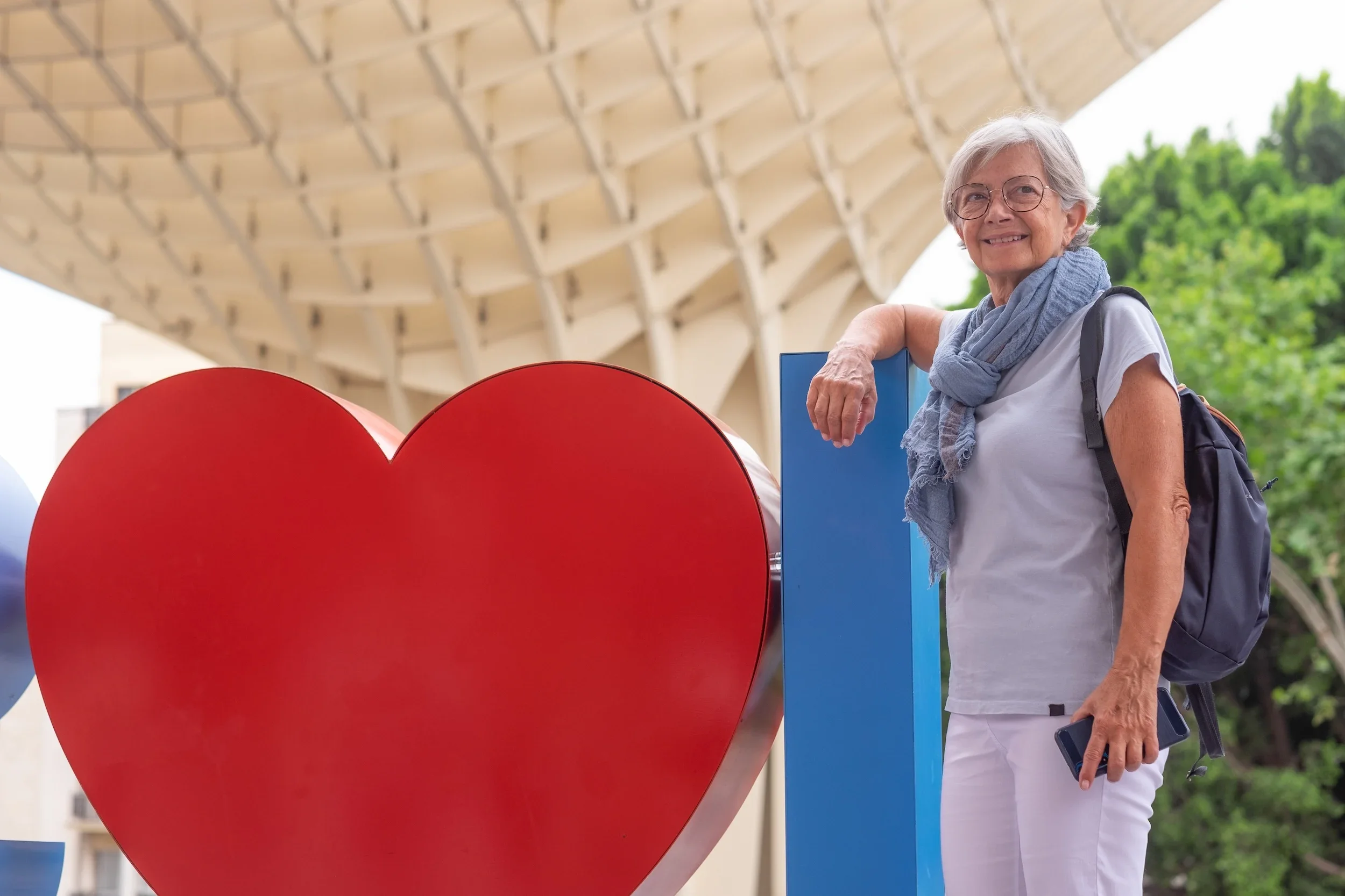 A woman standing beside a heart.