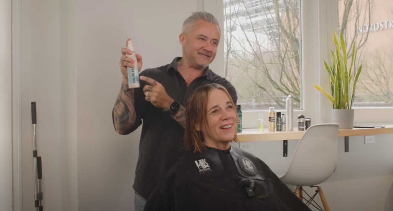 Stylist Justin Hickox demonstrating how to use Pureology Color Fanatic 21 on client Stephanie during her anti-frizz hair transformation.