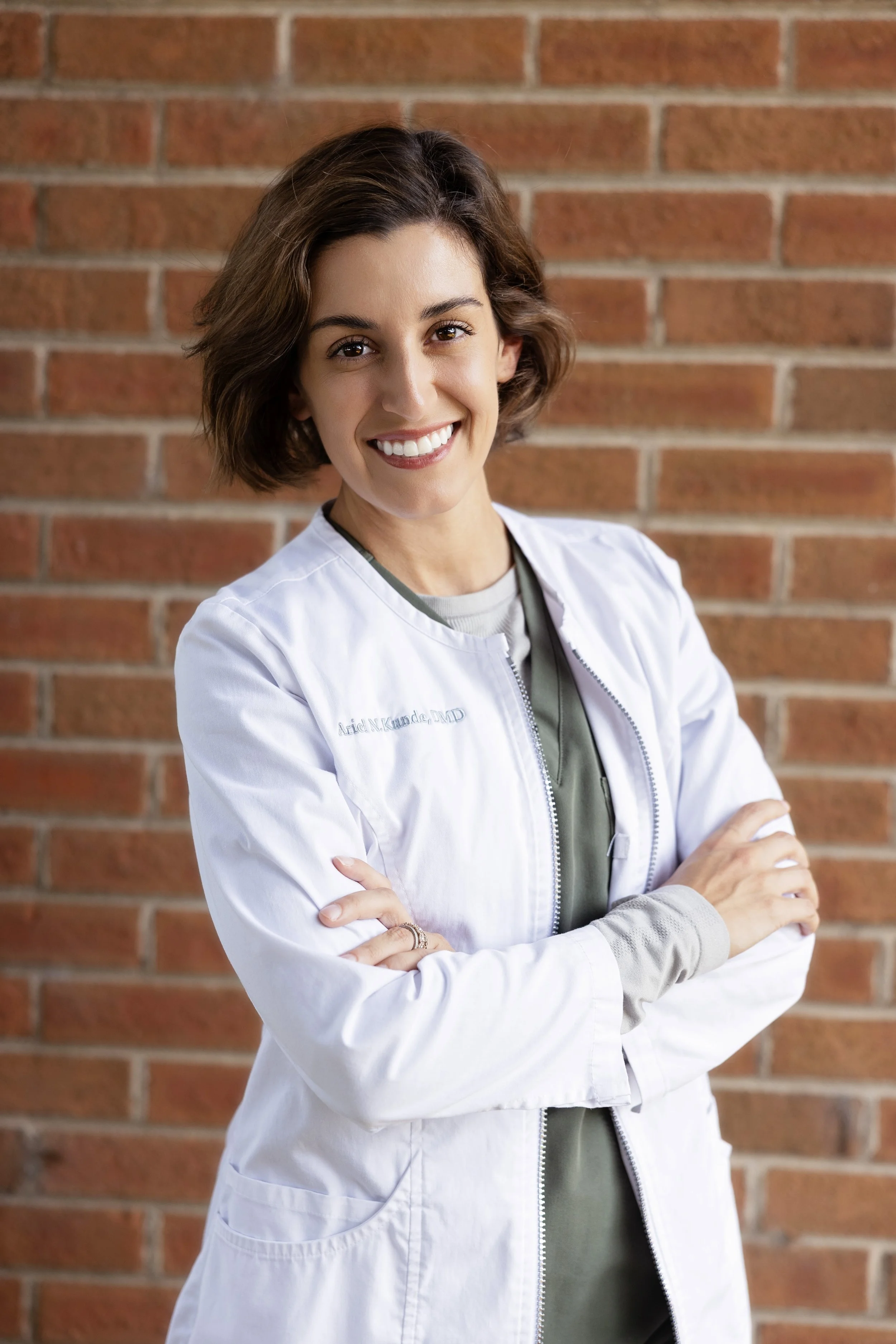 Headshot of Dr. Ariel Kunde Gastonia Family Dentist in front of a brick wall