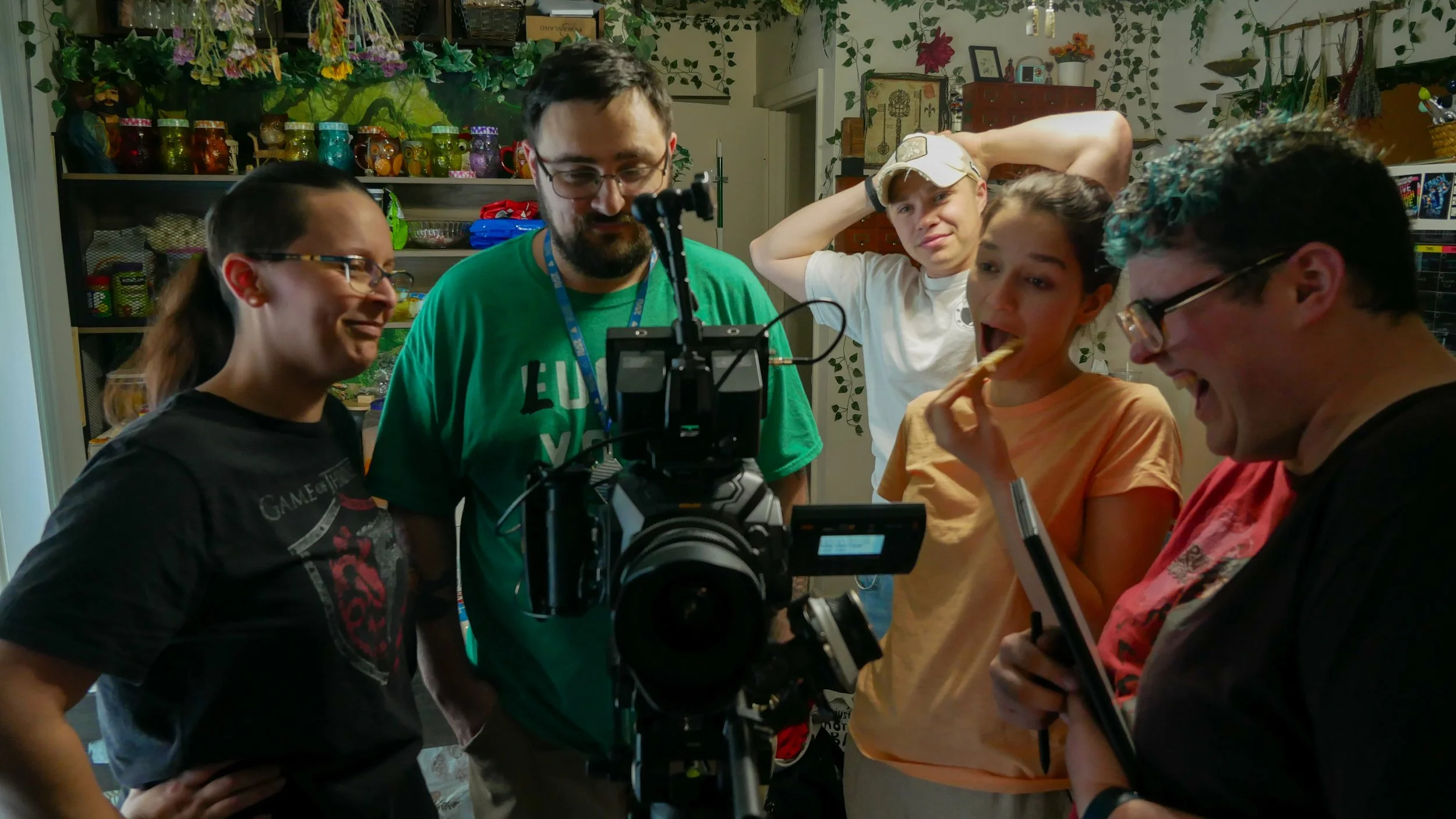 Alyssa Malloy and crew gather around a camera monitor, reviewing a scene with the director of photography and lead actor during filming of Script Keeper.