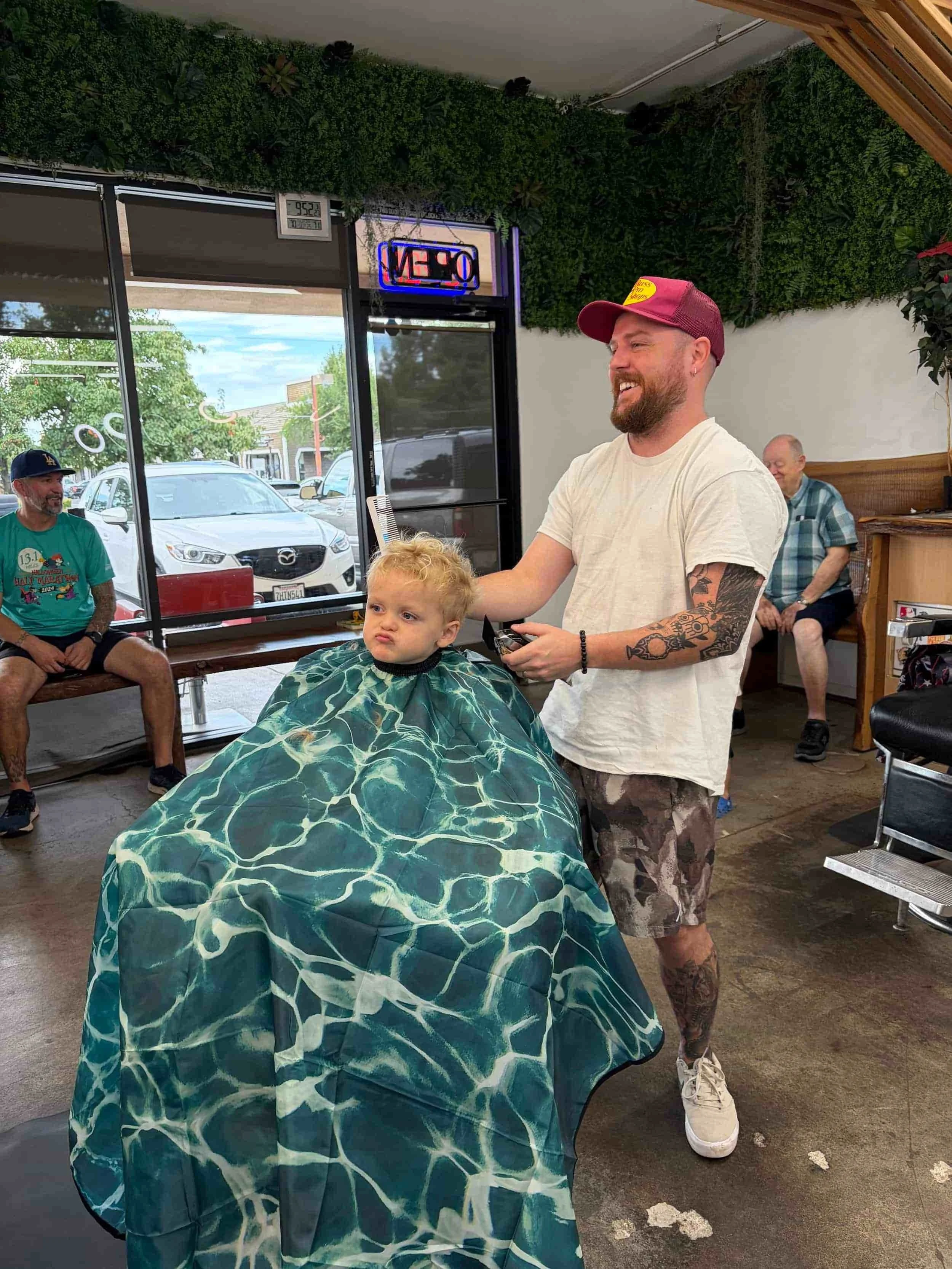 Professional barber giving a young boy a kids haircut at Redwood Barbershop in Folsom CA
