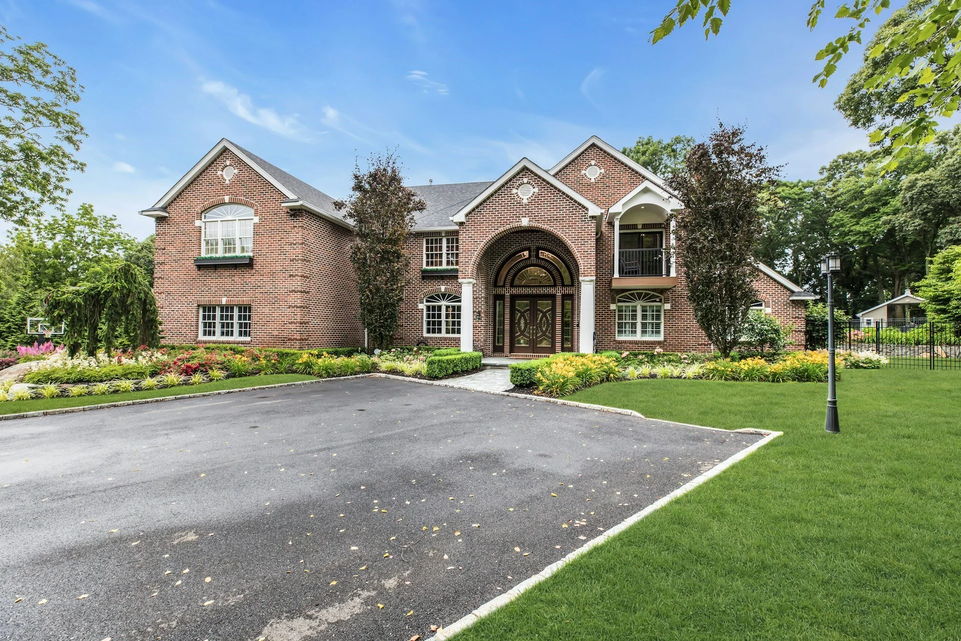 Large brick house with arched entrance and circular driveway