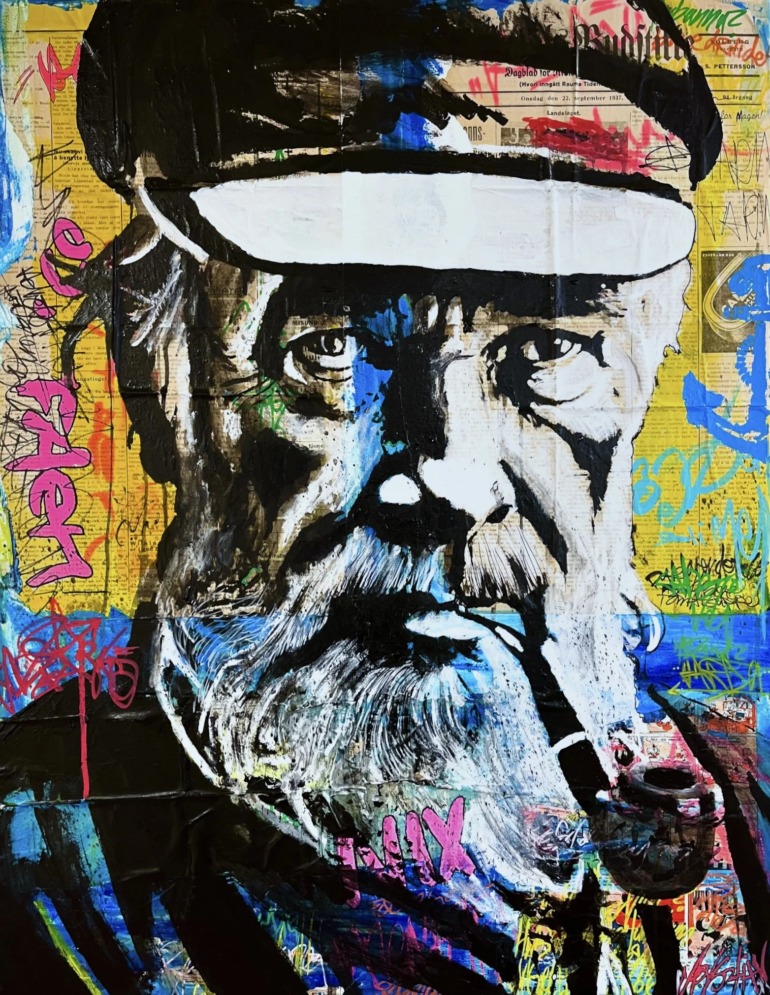 A graffiti-style portrait of a man with glasses, a beard, and a hat, painted on a collage background with various colorful words, scribbles, and newspaper clippings.