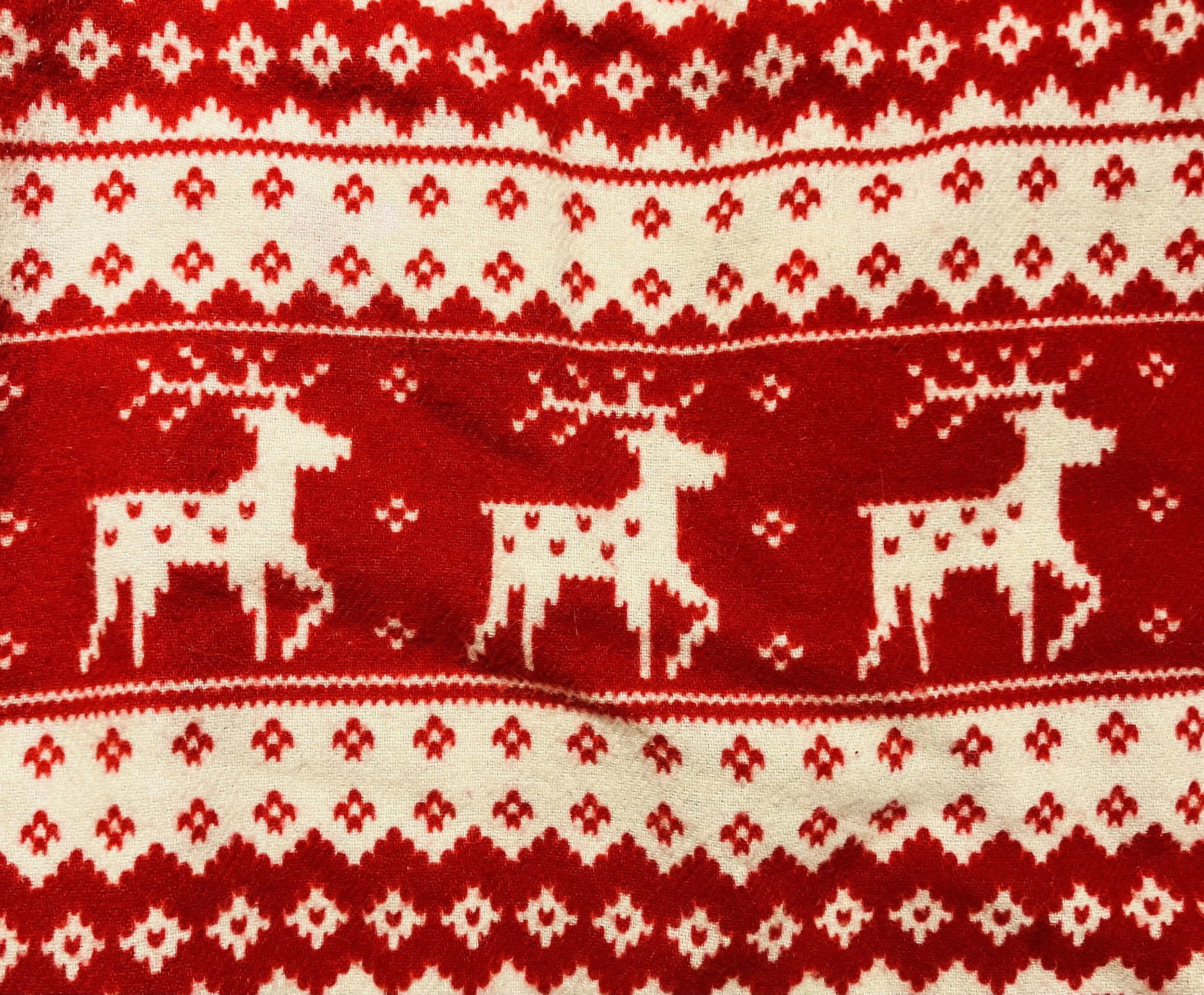 White reindeer on a festive red in a Nordic patterned holiday jammie pant.
