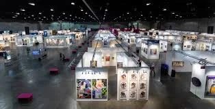 People socializing at a daytime indoor event with large windows and sunlight streaming in.