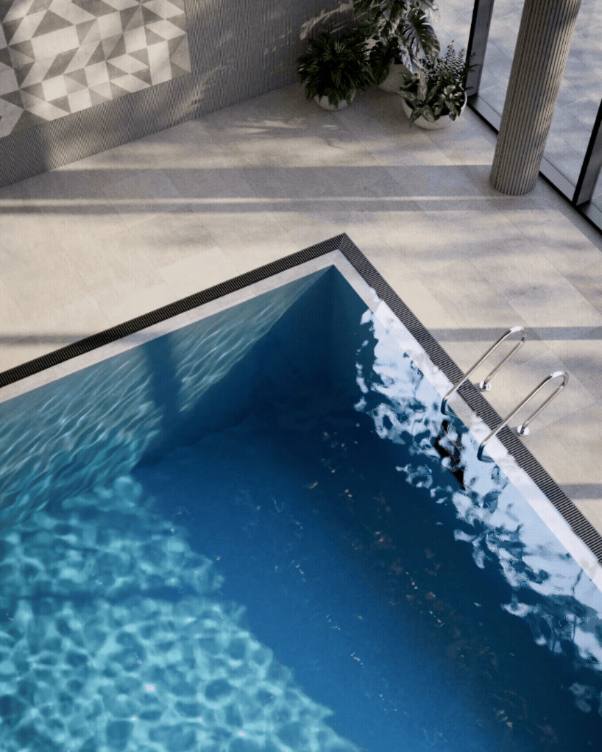 Indoor swimming pool in a modern building with large windows, plants, and a decorative wall.