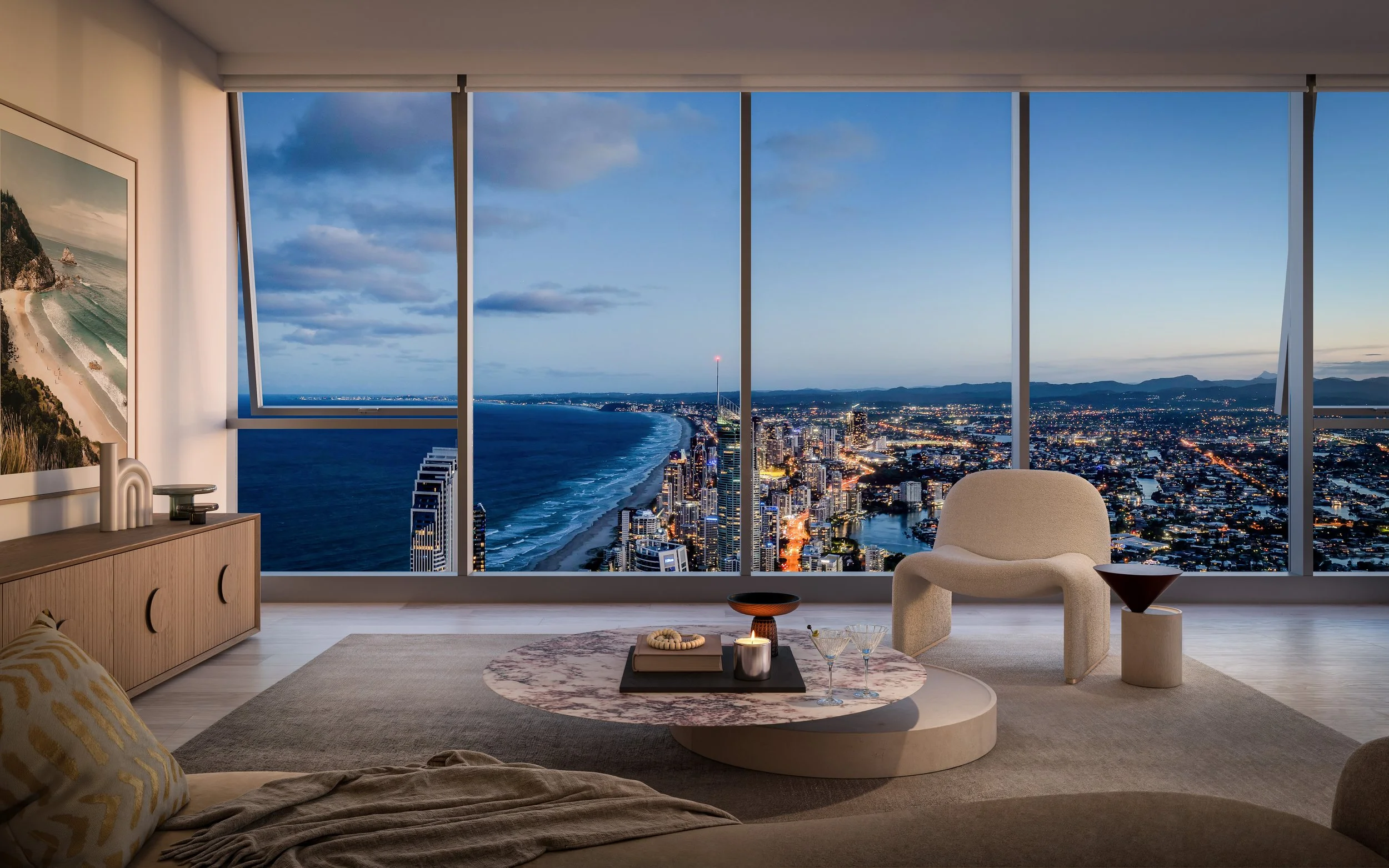 CGI render of living room with large floor-to-ceiling windows showcasing a gold coast skyline and ocean view at dusk, modern furniture including a white armchair, a coffee table with decorative items and drinks, and wall art.