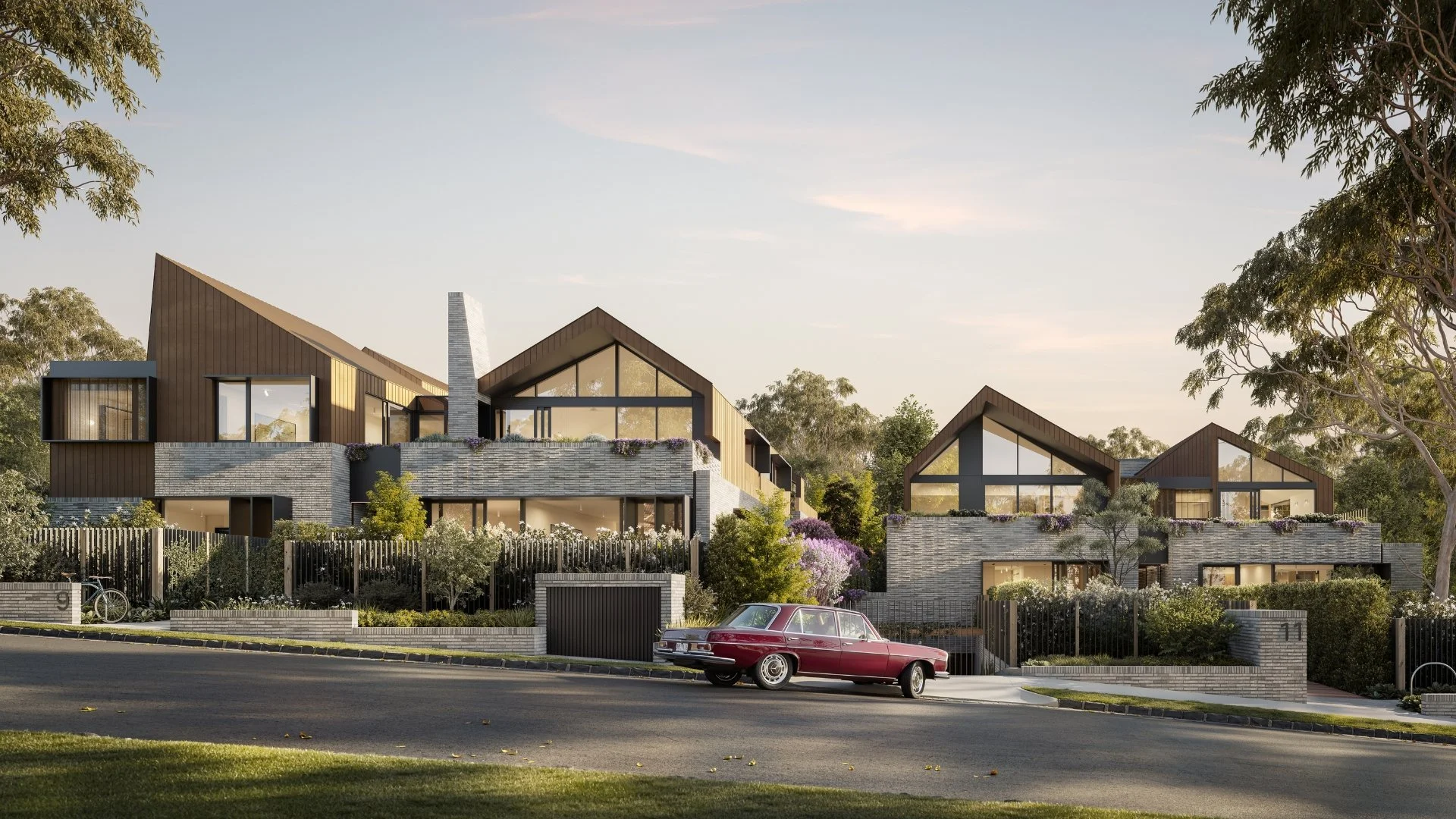 3D render of modern residential buildings with large glass windows, surrounded by greenery, with a red vintage car parked on the street in front.