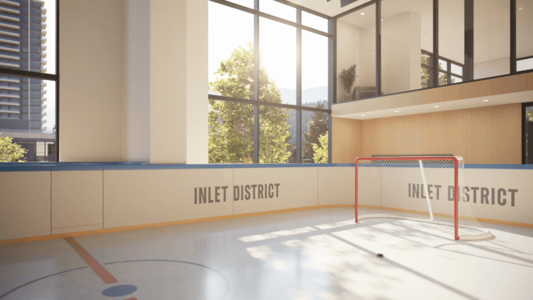 Indoor ice hockey rink with a red goal net, large windows with sunlight, and the words 'Inlet District' on the boards.