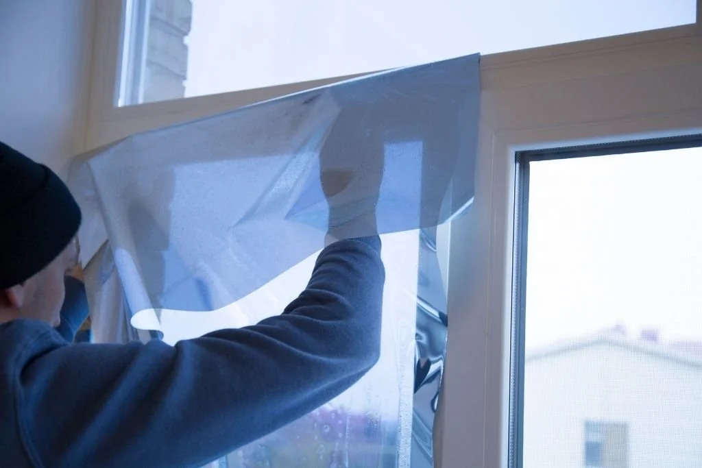 Professional installer applying window film to a glass window.