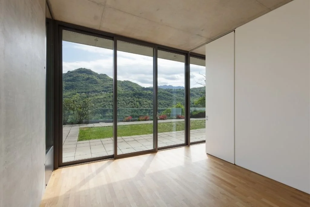 Modern home interior with large glass windows overlooking a landscape, ideal for residential window tinting to reduce heat and UV exposure