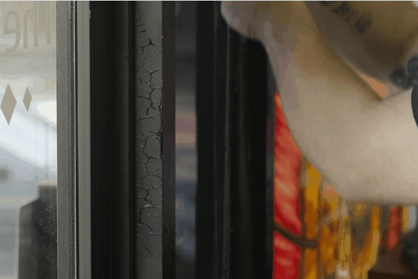 Close up of a window frame with visible cracking and wear on the seal next to a tinted glass panel. The image highlights the importance of professional window tinting in Texas to improve durability energy efficiency and long term window performance.