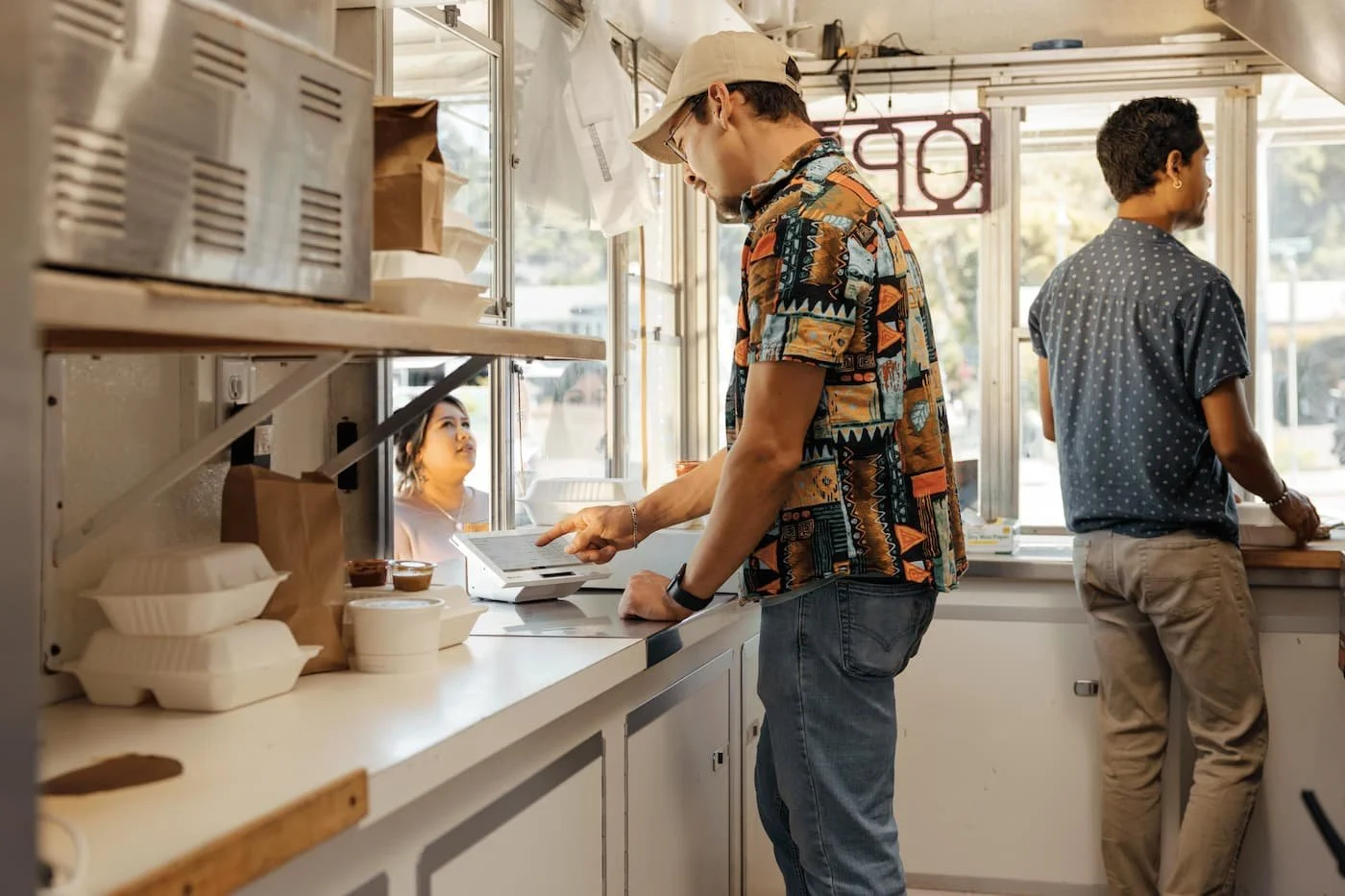 Customer ordering at a food truck window with Clover POS