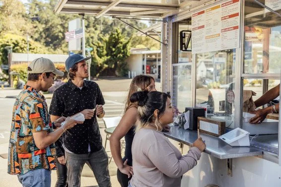 Customers ordering at a food truck counter with Clover POS