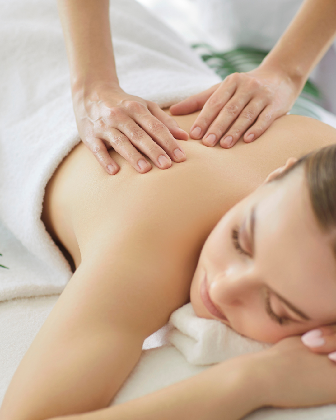 Person receiving a massage on their back in a spa setting.