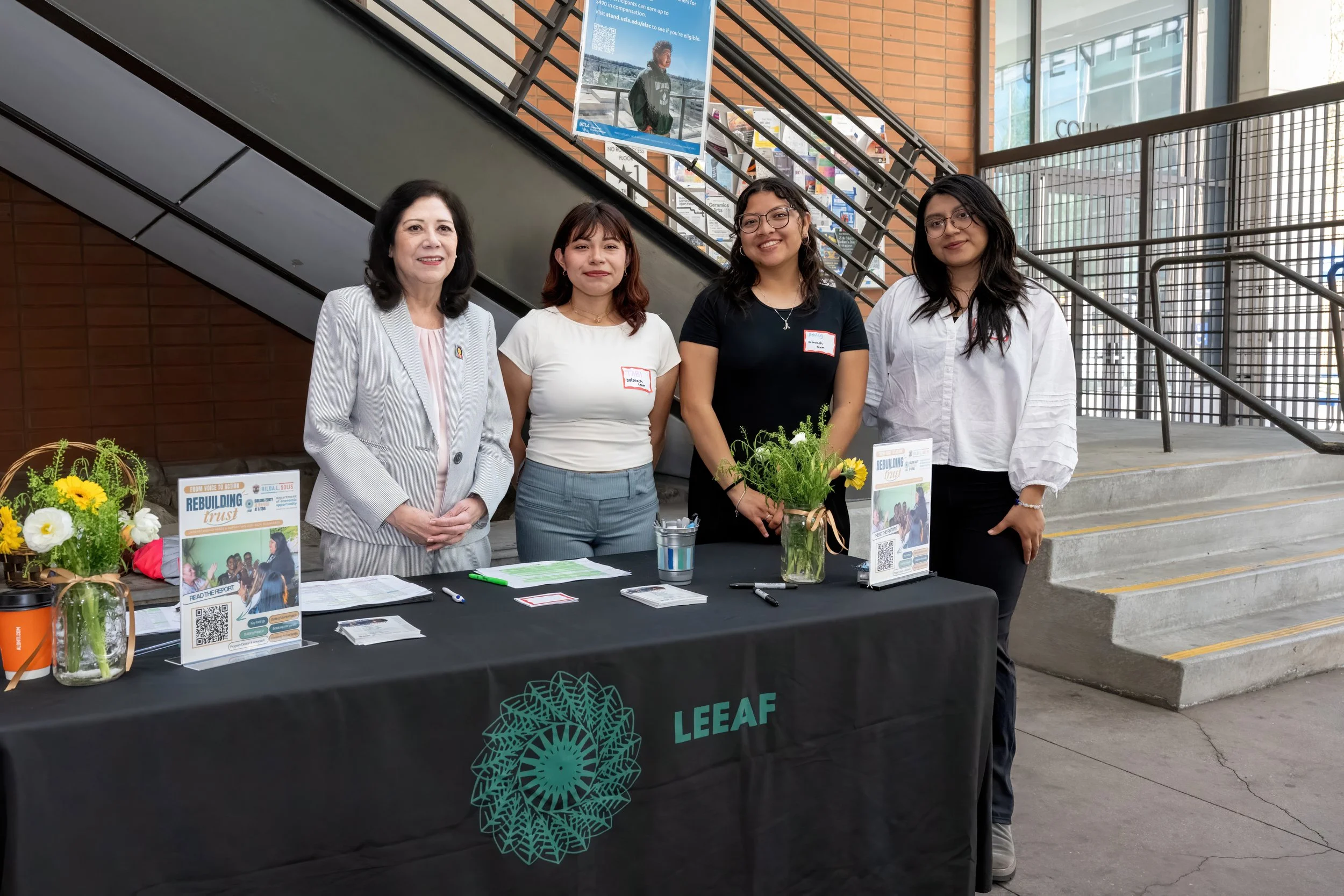 Four women behind a LEEAF booth at an event