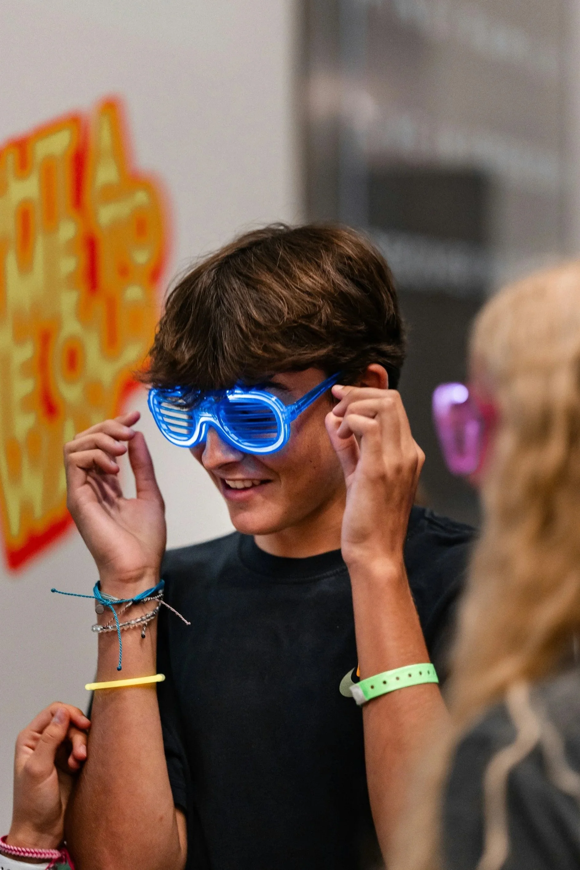 guy putting neon glasses on