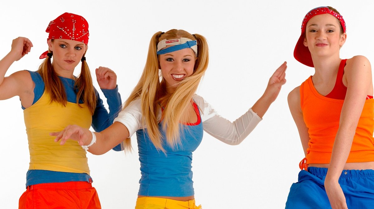 Three young women dressed in colorful sportswear striking playful poses against a white background.