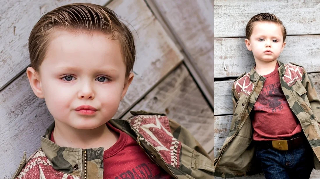 A young boy with short, light brown hair, wearing a camo jacket over a red graphic t-shirt, standing against a wooden background, with a serious expression.