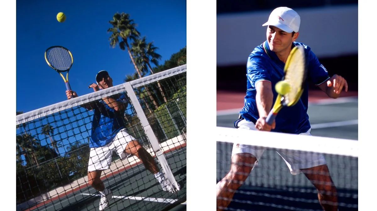 A tennis player hitting a ball on an outdoor court with palm trees and a clear blue sky in the background