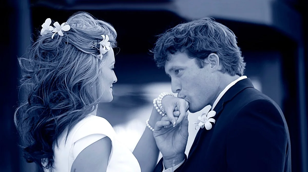 A man kissing a woman's hand during a wedding ceremony.