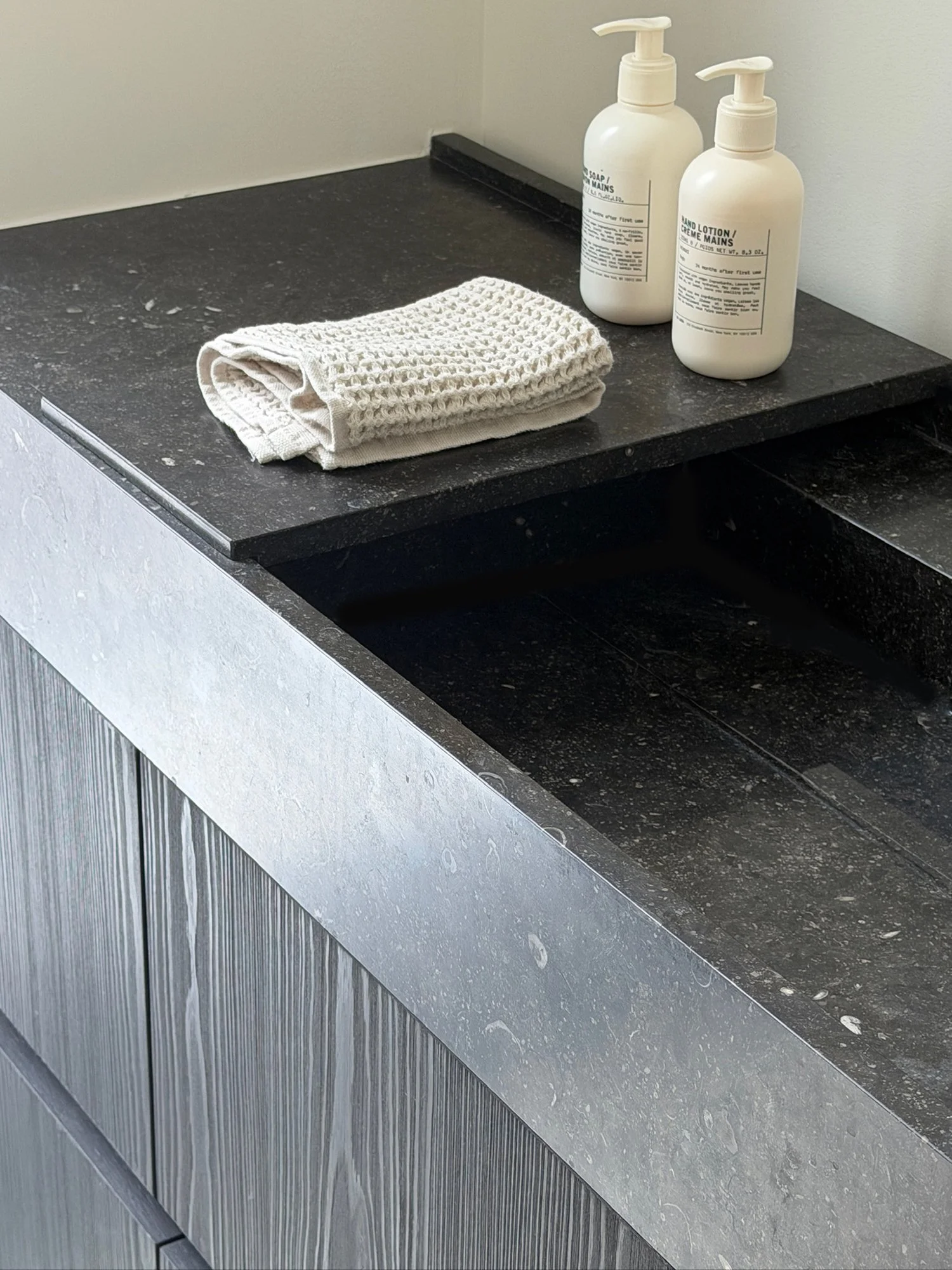 modern-bathroom-dark-stone-vanity-waffle-knit-towel-aesop-soap.jpg