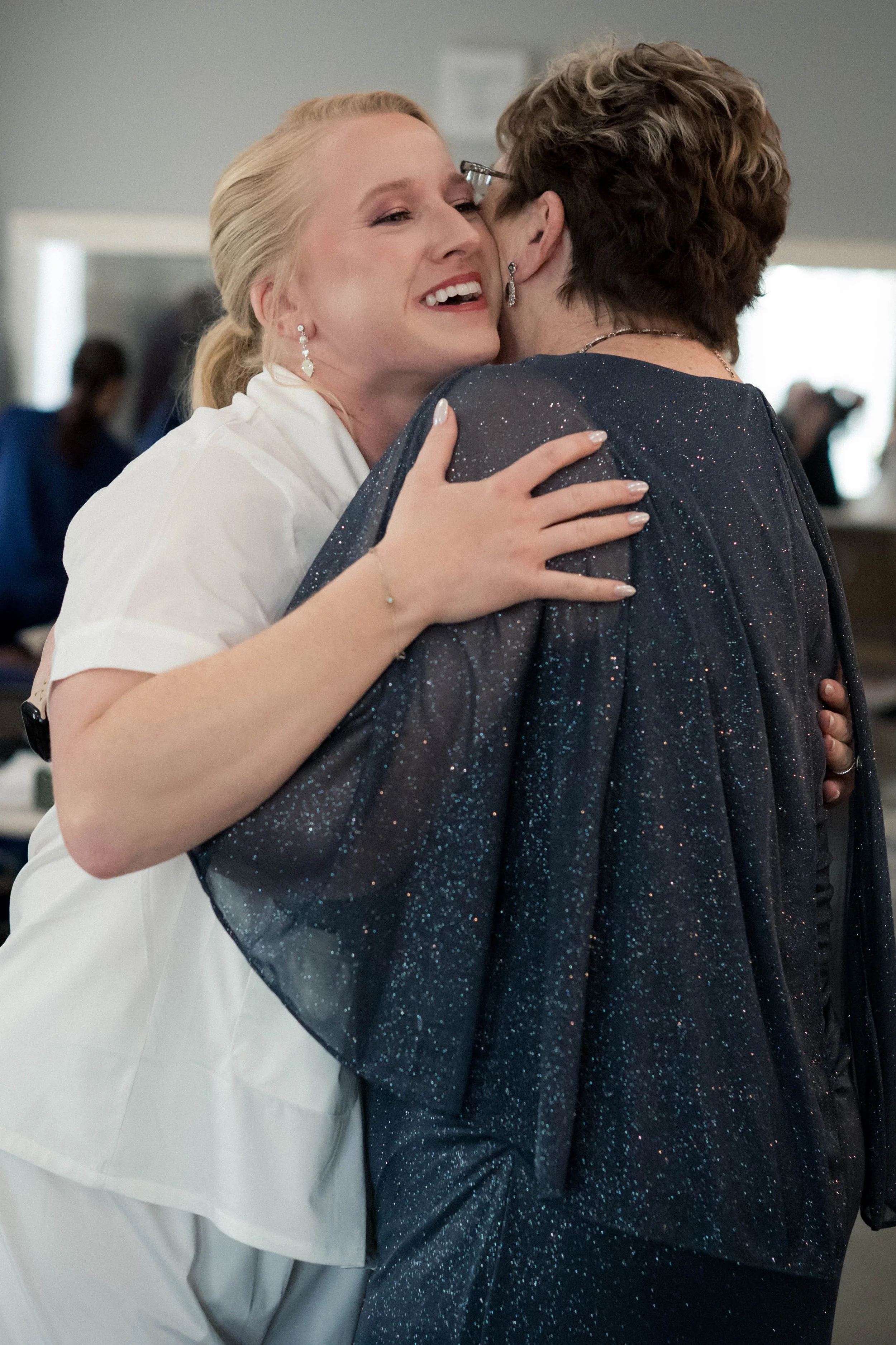 A candid moment captured of a bride hugging her mother while getting ready for her wedding.