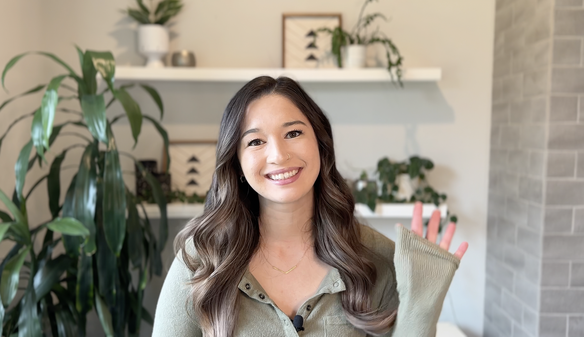 image of Kat smiling with hand raised in a wave