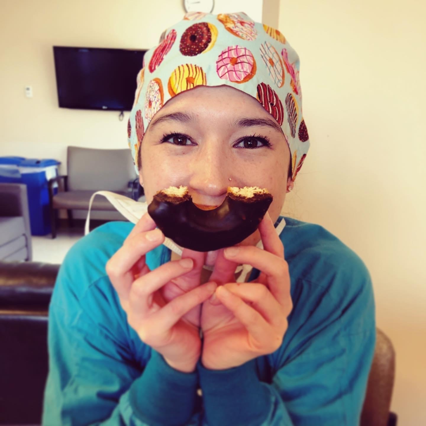 Kat holding half a donut to her face like a smile