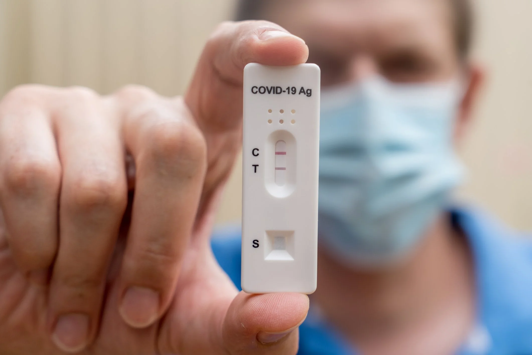 Photo of a person holding a positive COVID Rapid Antigen Test. Photo by Daria Nipot on iStock
