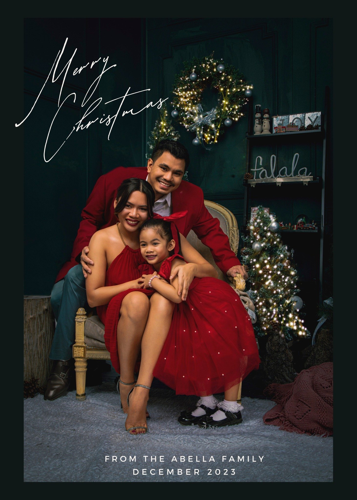 A family posing for a Christmas photo, with a Christmas tree and holiday decorations in the background. The family is dressed in festive attire, and there is a
