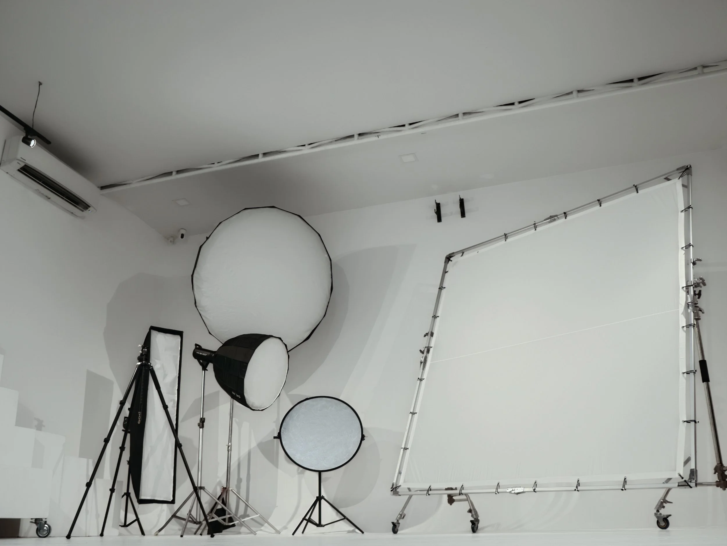 Photography lighting equipment and a wheeled backdrop frame set up inside The Factory Studio's white cyclorama in Cagayan de Oro.