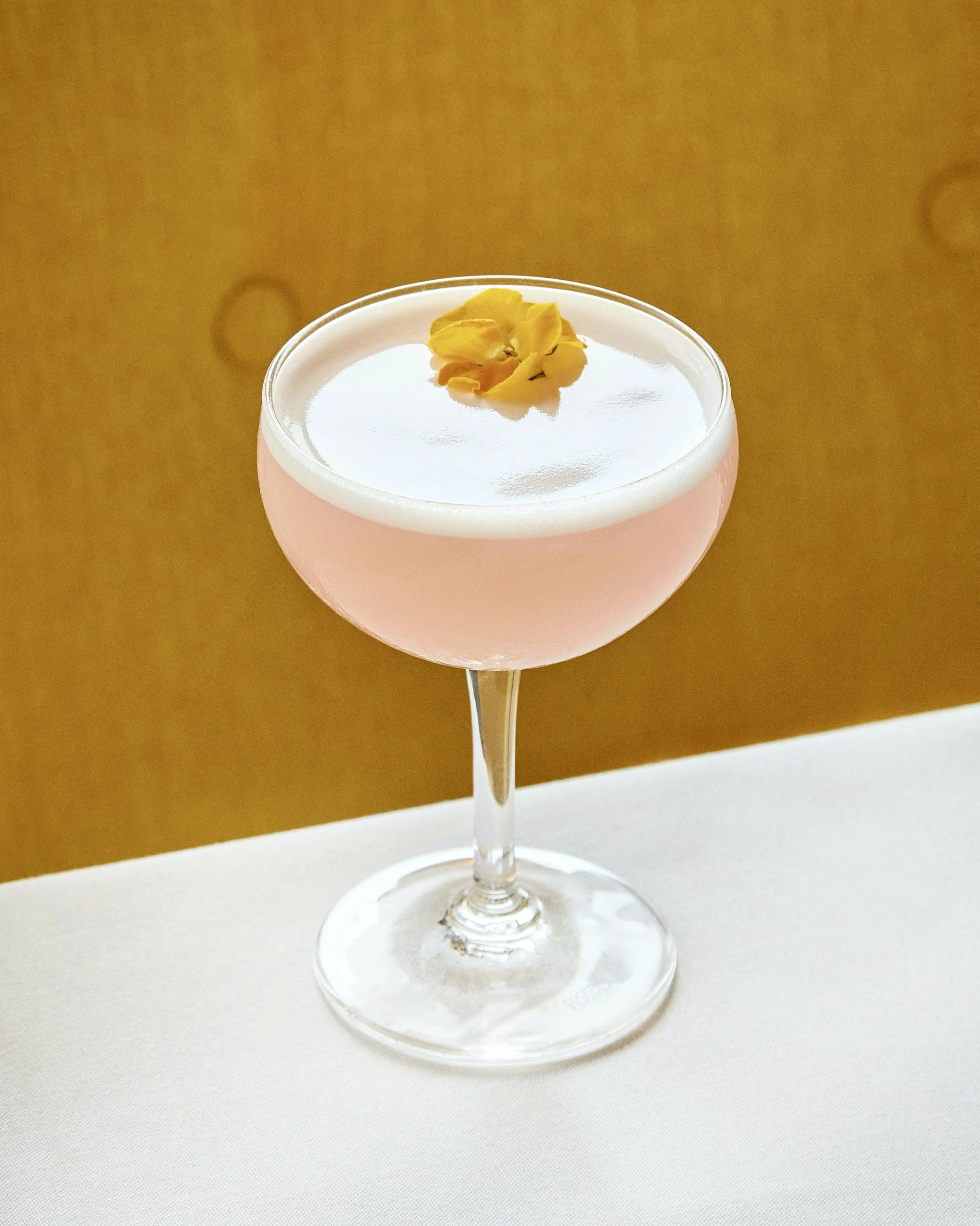 light pink cocktail with a flower