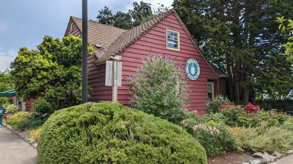 Red barn with flowers outside and Coffee Cottage sign