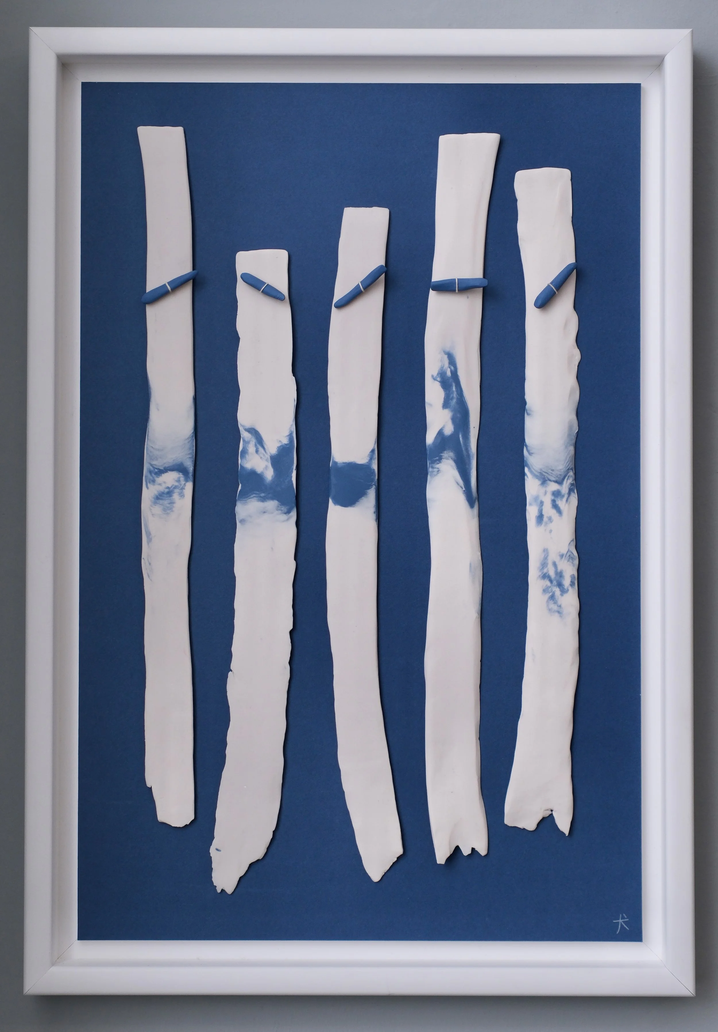 White paper strips with blue chalk marks on a blue background in a white frame.