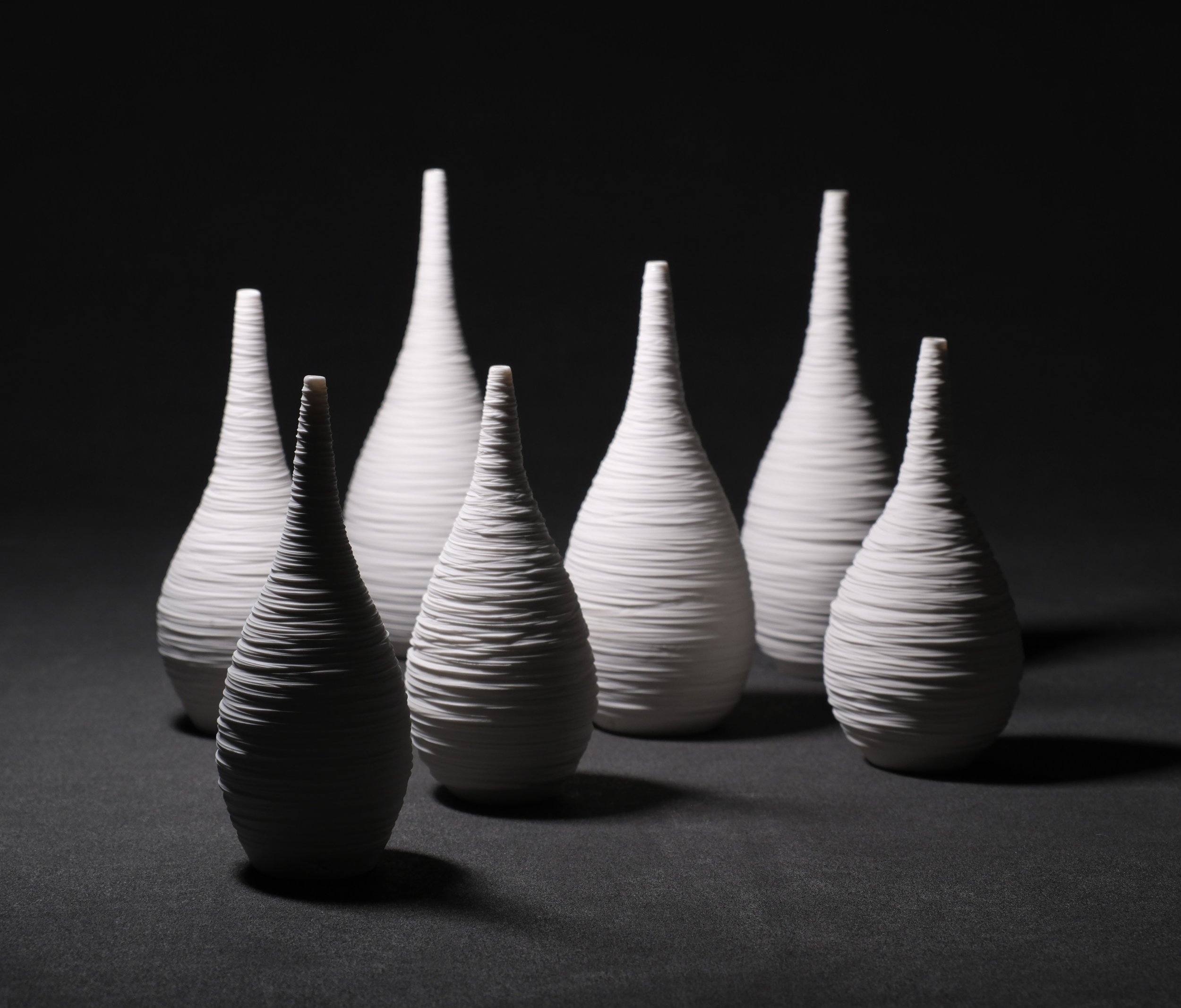 HOLD  STILL (tall) - a series of upright porcelain vessels that stand tall. Calm and meditative, these mindful vessels have been likened to nests. Carved naked exteriors that have the quiet strength of simply standing, "scarred" but composed.  The ta