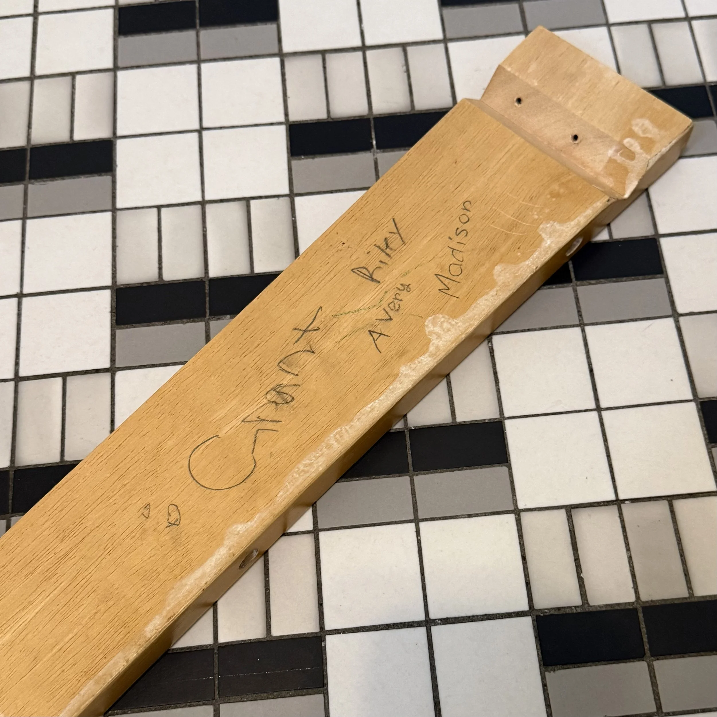 Continued... Madison Cantrell (@photomady), “We used to play under our kitchen table,” Digital photo of signed fragment of my family’s old kitchen table, iPhone 16 Pro Max, 2026.