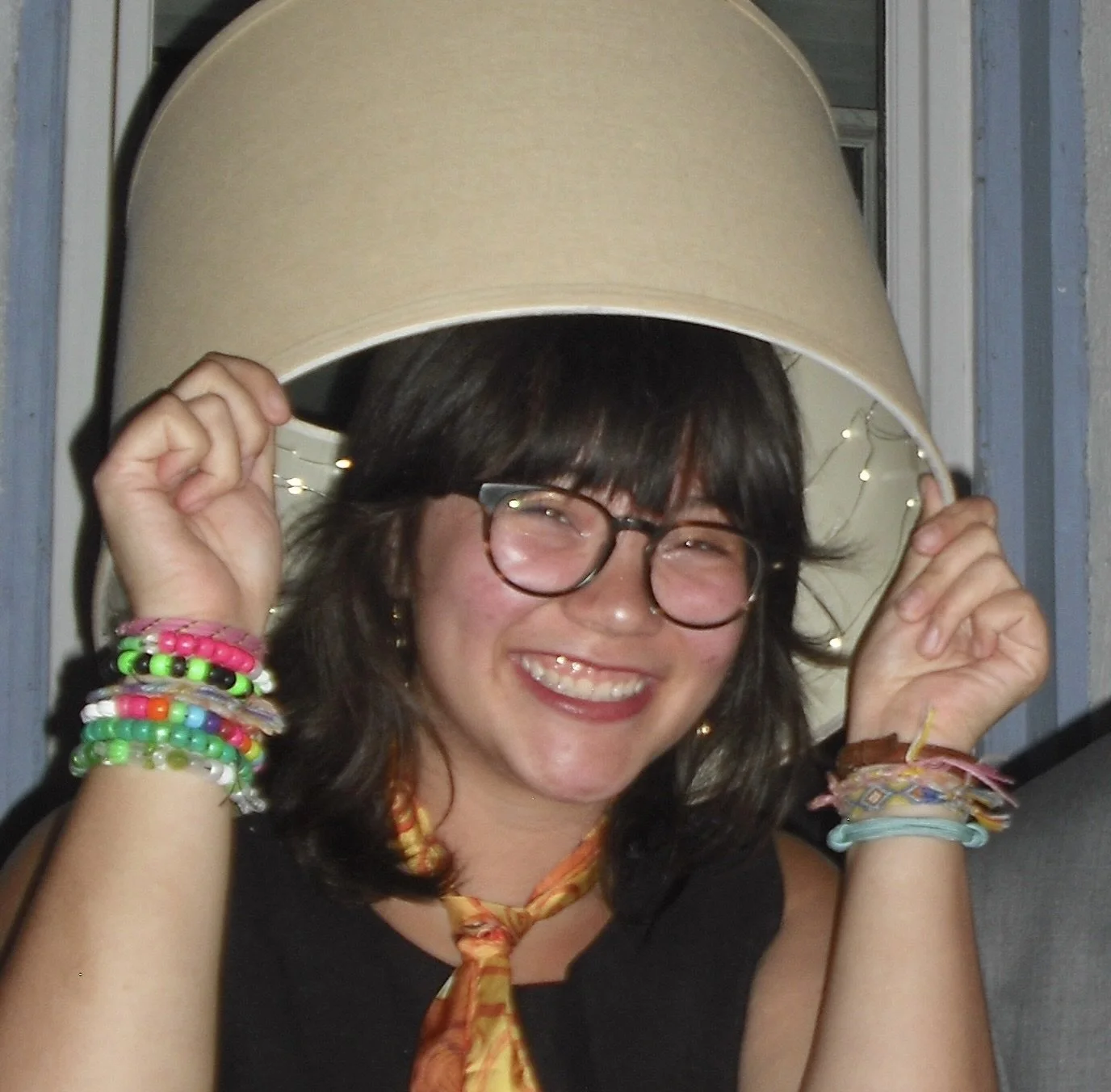 Mia wears a lampshade as a hat